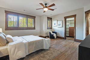 Bedroom with wood finished floors, a spacious closet, and a ceiling fan