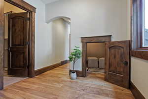 Hallway with light wood-style floors and arched walkways