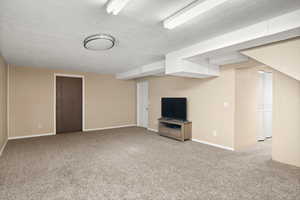 Second Family room eaturing light carpet and a textured ceiling