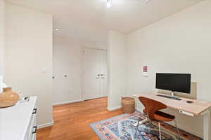 Office space featuring light wood finished floors and recessed lighting