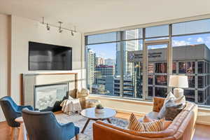 Sitting room featuring wood finished floors, a fireplace, and rail lighting