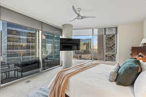 Bedroom with floor to ceiling windows, carpet flooring, ceiling fan, and access to exterior