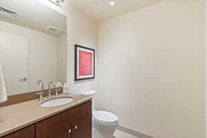 Half bathroom with vanity, light tile patterned floors, and recessed lighting