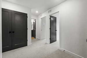 Corridor with light carpet and recessed lighting