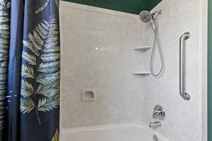 Bathroom with shower / bathtub combination with curtain