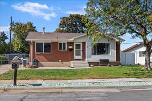 View of front of house with entry steps, brick siding, and roof with shingles