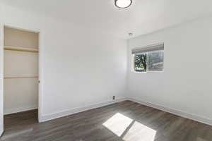 Unfurnished bedroom featuring dark wood finished floors and a closet