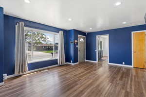Unfurnished living room with recessed lighting, dark wood-style flooring, and baseboard heating