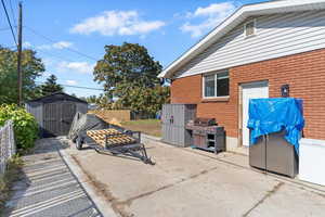 View of patio / terrace featuring a shed and a grill