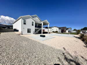 Back of property featuring stairs, board and batten siding, and a patio area