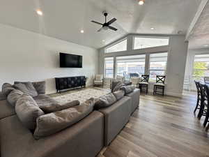 Living area with lofted ceiling, wood finished floors, recessed lighting, a textured ceiling, and ceiling fan