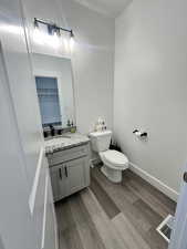 Half bathroom featuring light wood finished floors and vanity