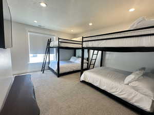 Bedroom with carpet flooring, a textured ceiling, and recessed lighting