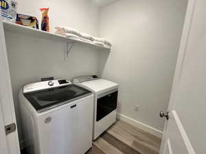 Washroom with light wood finished floors and separate washer and dryer