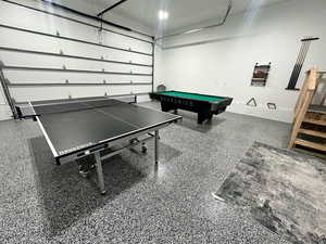 Recreation room featuring a garage, speckled floor, and billiards table