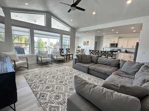 Living area with recessed lighting, light wood finished floors, vaulted ceiling, a textured ceiling, and a ceiling fan