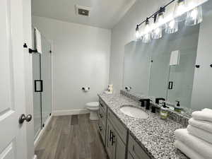 Bathroom featuring dark wood-style floors, vanity, and a stall shower