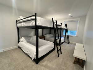 Bedroom with light colored carpet and recessed lighting