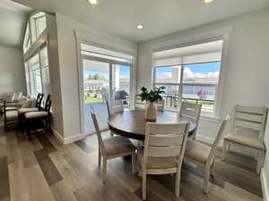 Dining room with wood finished floors, recessed lighting, and a textured ceiling