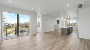 Images shown are of a similar completed unit. Unfurnished living room featuring recessed lighting and light wood finished floors