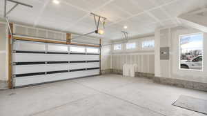 Images shown are of a similar completed unit. Garage with electric panel and a garage door opener