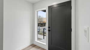 Images shown are of a similar completed unit. Doorway to outside with wood finished floors and baseboards