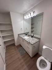 Bathroom with dark wood-style floors, a textured ceiling, and vanity