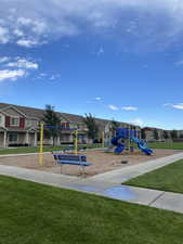 Communal playground featuring a lawn and a residential view