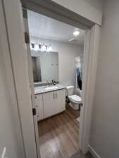 Bathroom featuring shower / bathtub combination with curtain, vanity, and dark wood finished floors