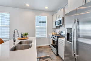 Kitchen with stainless steel appliances, gray cabinetry, recessed lighting, and quartz counters