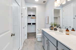Primary Full bath with a walk-in closet, a shower stall, and vanity
