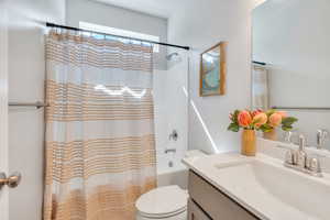Bathroom featuring shower / bathtub combination with curtain and vanity