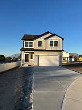 View of front of property featuring a mountain view, driveway, and a garage
