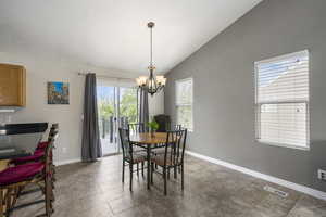 Dining area featuring vaulted ceiling and a chandelier