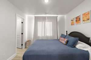 Bedroom with wood finished floors and a textured ceiling