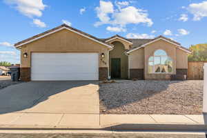 Ranch-style home featuring concrete driveway, an attached garage, stucco siding, a tiled roof, and brick siding