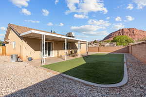 Rear view of property with a patio, stucco siding, a fenced backyard, and a mountain view