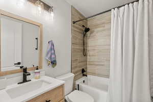Full bathroom with shower / bath combination with curtain and vanity