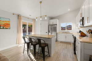 Kitchen featuring light stone countertops, decorative backsplash, appliances with stainless steel finishes, a kitchen bar, and recessed lighting