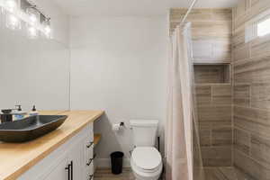 Full bath with vanity, a stall shower, and light wood-style floors