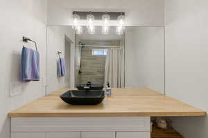 Full bathroom featuring a tile shower and vanity