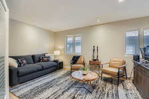 Living room with plenty of natural light, light wood-style flooring, and recessed lighting