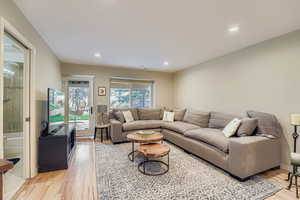 Living area with light wood finished floors and recessed lighting