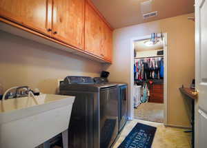 Washroom featuring cabinet space, independent washer and dryer, and light colored carpet