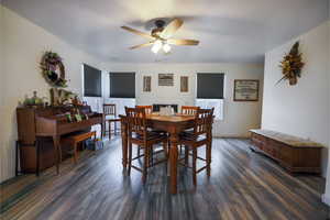 Dining space with dark wood-style flooring and a ceiling fan