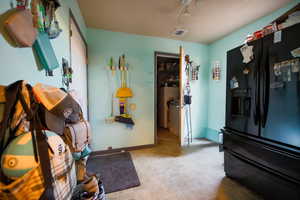 Bedroom featuring black refrigerator with ice dispenser and baseboards