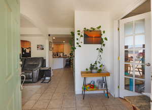 Corridor with arched walkways, light tile patterned floors, and recessed lighting