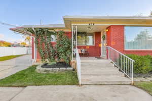 View of front of property featuring covered porch and brick siding