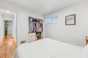 Bedroom with wood finished floors and a closet