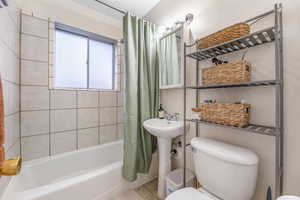 Full bathroom with shower / bath combination with curtain and tile patterned flooring
